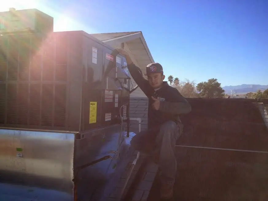 HVAC technician performing HVAC Inspection on a rooftop unit in Burnet